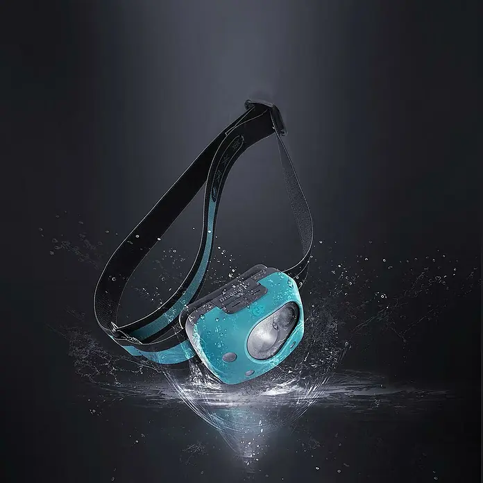 GP Stirnlampe CH44 - 61 x 47 x 37,3 mm, 35 lm - 300 lm, IPX4 - Das Bild zeigt eine blaue Stirnlampe mit einem schwarzen Stirnband, umgeben von Wassertropfen, die ihre Wasserdichtigkeit betont.