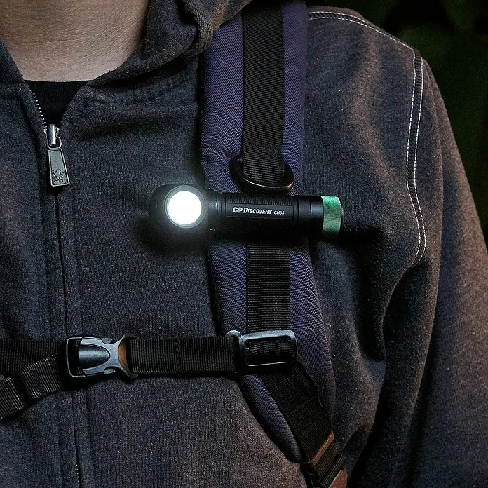 GP Stirnlampe /Taschenlampe CH35 - 15 lm - 600 lm, IPX4 - Nahaufnahme einer GP Discovery CH35 Stirnlampe, die an einem Rucksack befestigt ist und hell leuchtet. Ideal für Outdoor-Aktivitäten.