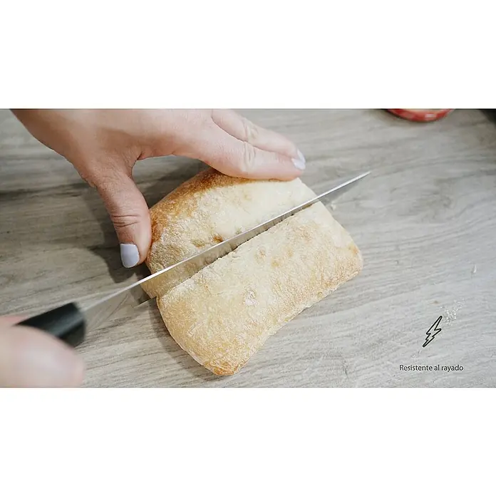 Mesa de jardín Mistral - L x An x Al: 192 x 102 x 74 cm, Aluminio/Cerámica, Antracita - Un pan ciabatta está siendo cortado con un cuchillo sobre una mesa, destacando la durabilidad de la mesa.