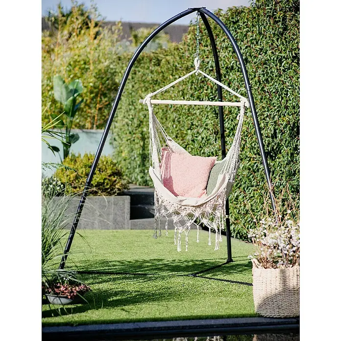Gancho de asiento - Carga soportada: 120 kg - Una silla hamaca con cojines colgada de un soporte en un jardín, rodeada de vegetación. Ideal para relajarse al aire libre.