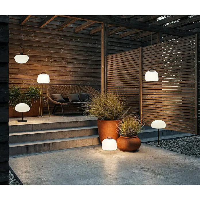 Nordlux Sponge Akku-Pendelleuchte Sponge - 4,8 W, Warmweiß - Eine stimmungsvolle Szene mit mehreren modernen Außenleuchten, die eine gemütliche Atmosphäre im Freien schaffen.