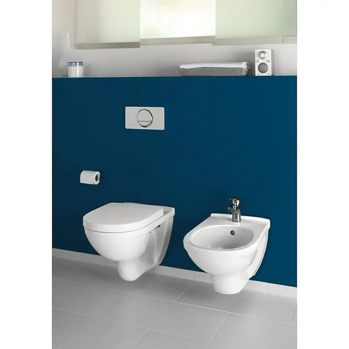 Villeroy & Boch O.novo Wand-WC-Set - Spülrandlos, Mit schmutzabweisender Glasur, Spülform: Tief, WC Abgang: Waagerecht, Weiß - Elegantes Badezimmer-Design mit einer wandmontierten Toilette und Bidet in Weiß vor einer stilvollen, tiefblauen Wand.