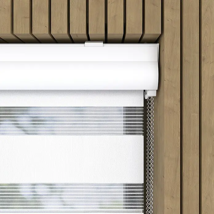 Expo Ambiente Doppelrollo mit Kassette - B x H: 90 x 220 cm, Weiß, Tageslichtdurchlässig - Eine Nahaufnahme einer weißen Rolljalousie mit einem Kettenzug vor einem hölzernen Hintergrund, die das elegante Design und die Funktionalität hervorhebt.