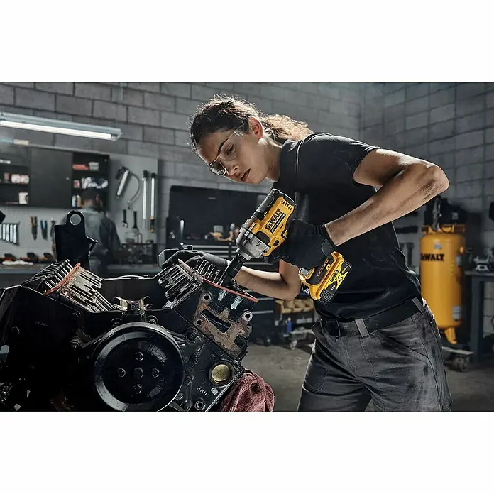 DeWalt XR 18V Llave de impacto de batería DCF891NT - 18 V, Sin batería, 1.084 Nm - Una persona utiliza una llave de impacto DeWalt amarilla en un motor de coche para aflojar un perno.