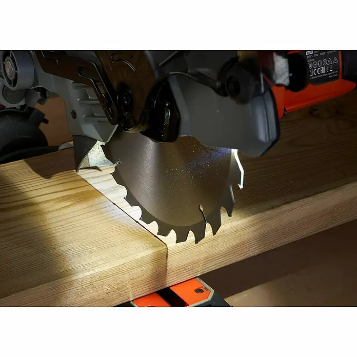 Black+Decker Sierra ingletadora BES702 - 1.500 W, Diámetro hoja de sierra: 216 mm, Número de revoluciones de marcha en vacío: 5.000 r.p.m. - Primer plano de una sierra de inglete cortando una tabla de madera, centrándose en la hoja de sierra afilada y la acción de corte.