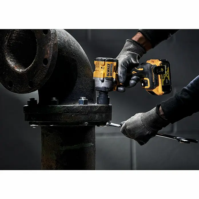 DeWalt XR 18V Llave de impacto de batería DCF921N - 18 V, Sin batería, 610 Nm - La llave de impacto inalámbrica DeWalt en acción, apretando un perno en una gran estructura metálica. Una herramienta esencial para tareas pesadas.