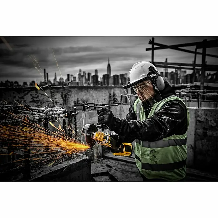 DeWalt XR 18V Amoladora angular de batería DCG409NT - 18 V, Sin batería - Un trabajador de la construcción utiliza una amoladora angular amarilla Dewalt, con chispas.
