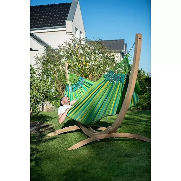 La Siesta Hängematte Brisa Kingsize - L x B: 400 x 180 cm, Lime - Mann entspannt in einer gestreiften grün-gelben Stoffhängematte auf einem Holzgestell.