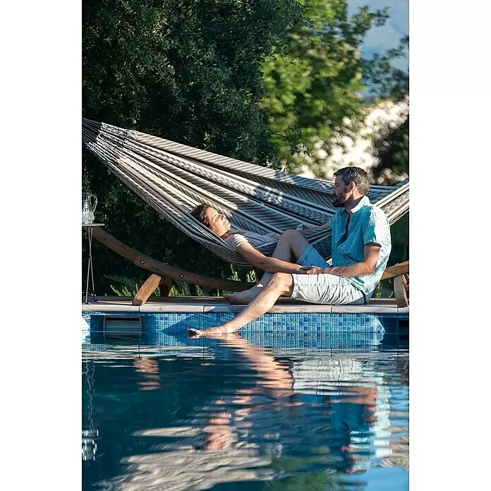 La Siesta Doppelhängematte Flora - L x B: 350 x 160 cm, Zebra, Ausführungseigenschaft: Double - Grau-weiß gestreifte Hängematte, mit zwei Personen an einem Pool, bietet Entspannung im Garten.
