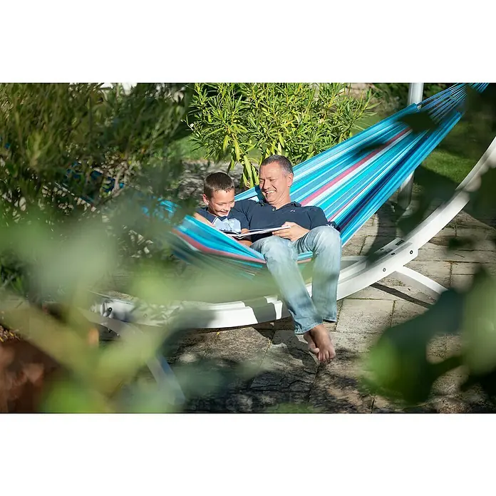 La Siesta Hängematte Brisa Kingsize - L x B: 400 x 180 cm, Wave - Ein Vater und sein Sohn entspannen sich in einer bunten Hängematte im Garten und lesen gemeinsam ein Buch.