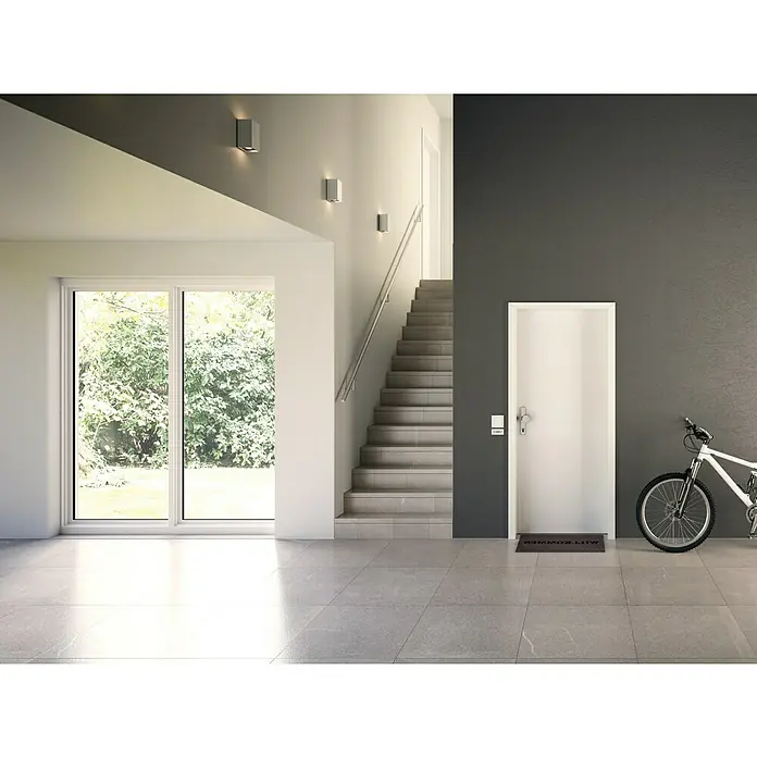 GetaDoor Laminit Wohnungseingangstür GL 223Klimaklasse nach RAL: II, 860 x 2.110 mm, DIN Anschlag: Links, Weiß seidenmatt - Helle Eingangshalle mit einer weißen Tür, Treppe und einem Fahrrad an der Wand. Moderne Architektur und einladendes Design.