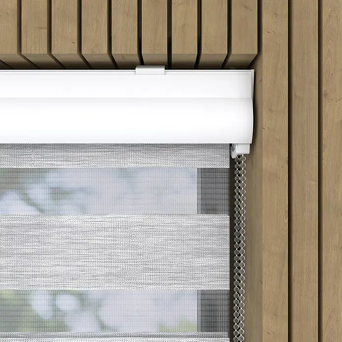 Doppelrollo mit KassetteB x H: 90 x 175 cm, Hellgrau - Nahaufnahme einer weißen Doppelrollo, die teilweise vor einem hölzernen Hintergrund heruntergelassen ist, und ihre elegante Funktionalität hervorhebt.
