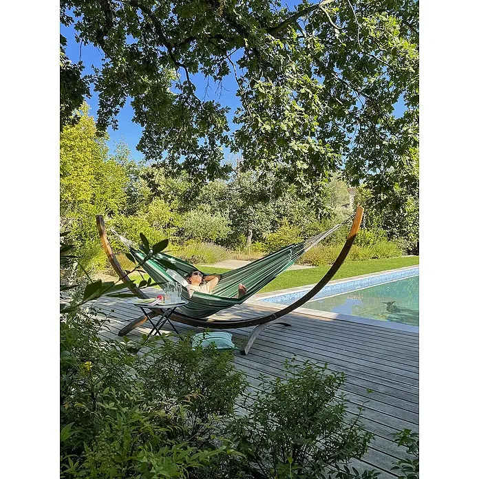 La Siesta Hängematte Modesta - L x B: 350 x 160 cm, Agave, Double - Entspannung pur: Frau genießt die Ruhe in einer grünen Hängematte auf einer hölzernen Terrasse neben einem Pool an einem sonnigen Tag.