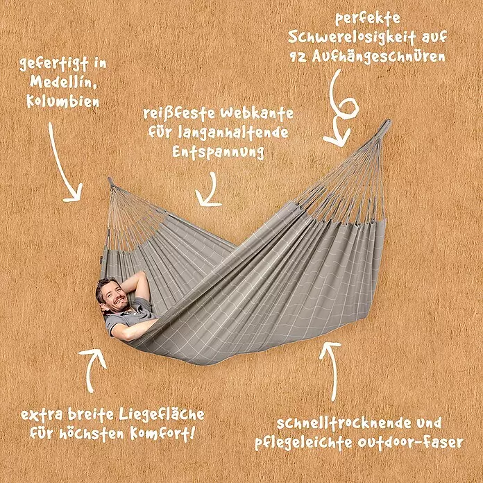 La Siesta Hängematte Brisa Kingsize - L x B: 400 x 180 cm, Almond - Graue Hängematte mit Karomuster, in der ein Mann entspannt liegt. Sie ist extrabreit, schnelltrocknend und pflegeleicht.