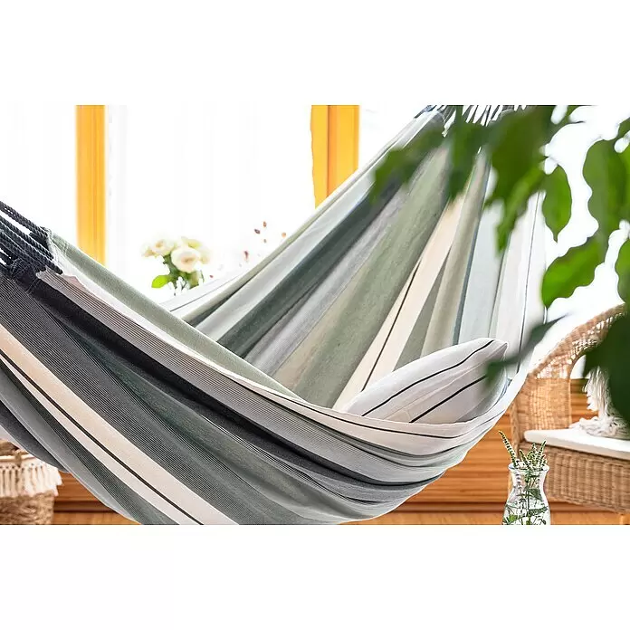 La Siesta Hängematte Modesta - L x B: 350 x 160 cm, Olive, Double - Gestreifte Stoffhängematte in Grün, Weiß und Grau, drinnen mit Kissen an einem hellen Fenster.