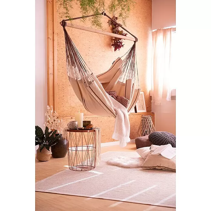 La Siesta Hängesessel Habana Kingsize - L x B x H: 210 x 130 x 170 cm, Nougat - Beiger Hängesessel mit braunen Seilen und Holzstange, gefüllt mit Decke und Kissen, in einem gemütlichen, warmen Raum.