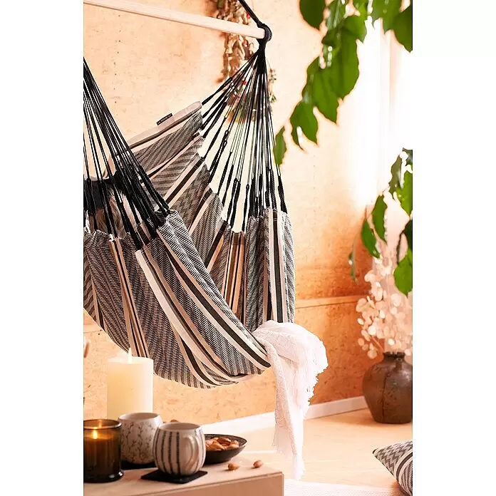 La Siesta Hängesessel Habana Kingsize - L x B x H: 210 x 130 x 170 cm, Zebra - Gestreifter Stoff-Hängesessel in Schwarz, Weiß und Beige, in einem gemütlichen Innenraum mit Kerzen und Pflanzen hängend.