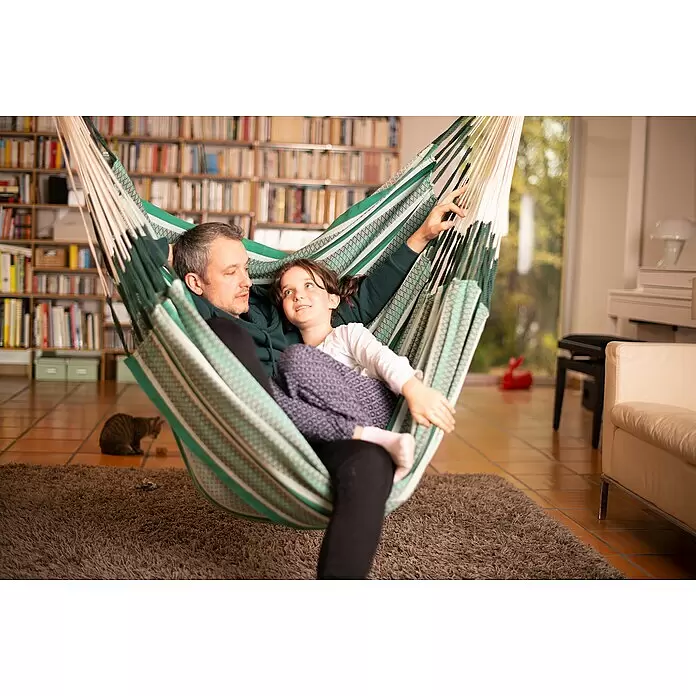 La Siesta Hängesessel Habana Kingsize - L x B x H: 210 x 130 x 170 cm, Agave - Grün-weiß gestreifte Stoffhängematte, in der Vater und Tochter drinnen bequem liegen.
