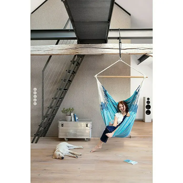 La Siesta Hängesessel Habana Kingsize - L x B x H: 210 x 130 x 170 cm, Azure - Die junge Frau entspannt in einer blauen Hängematte in einem modernen Loft mit Holzbalken und Treppe. Der Hund schläft friedlich daneben.
