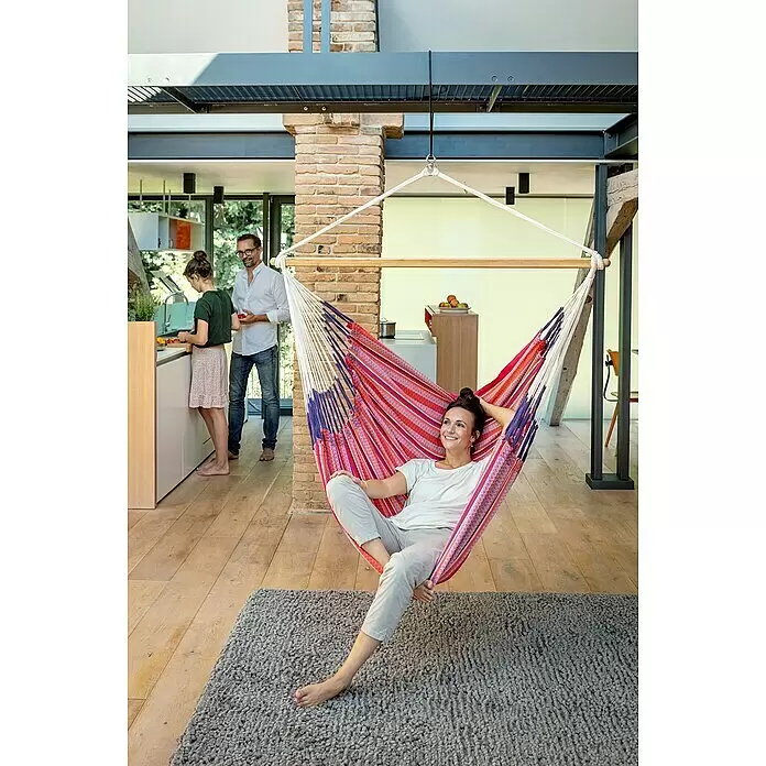 La Siesta Hamaca colgante Habana Kingsize - L x An x Al: 210 x 130 x 170 cm, Rojo/Blanco - Mujer relajándose en una silla colgante de rayas rojas, moradas y blancas en el interior.