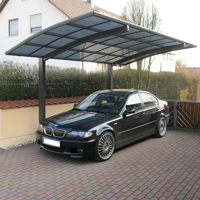 Ximax Carport Portoforte 60 - Außenmaß inkl. Dachüberstand (B x T): 2,7 x 4,95 m, Einzelcarport, Mattbraun, Schneelast: 75 kg/m² - Schwarzer BMW 3er geparkt unter einem Carport mit Stahlrahmen und transparentem Dach. Das Auto steht auf einem gepflasterten Hof.