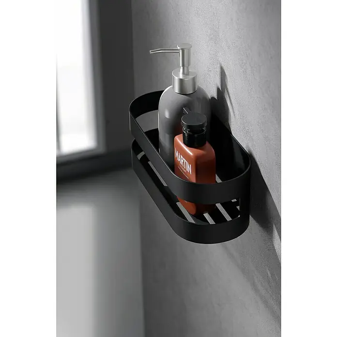 Imex Cesta de baño Nirmala - 10,4 x 25 x 9 cm, Acero inoxidable, Negro - Un estante de ducha negro con dos productos de cuidado personal, un dispensador de jabón gris y una loción marrón, montado en la pared.