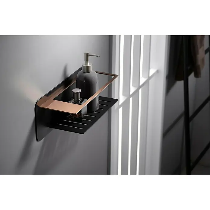 Imex Cesta de baño Bethari - 12,7 x 36 x 13,5 cm, Acero inoxidable, Negro/Oro rosa - Una estantería de baño flotante negra con detalles en bronce exhibe con estilo champú y una botella pequeña.