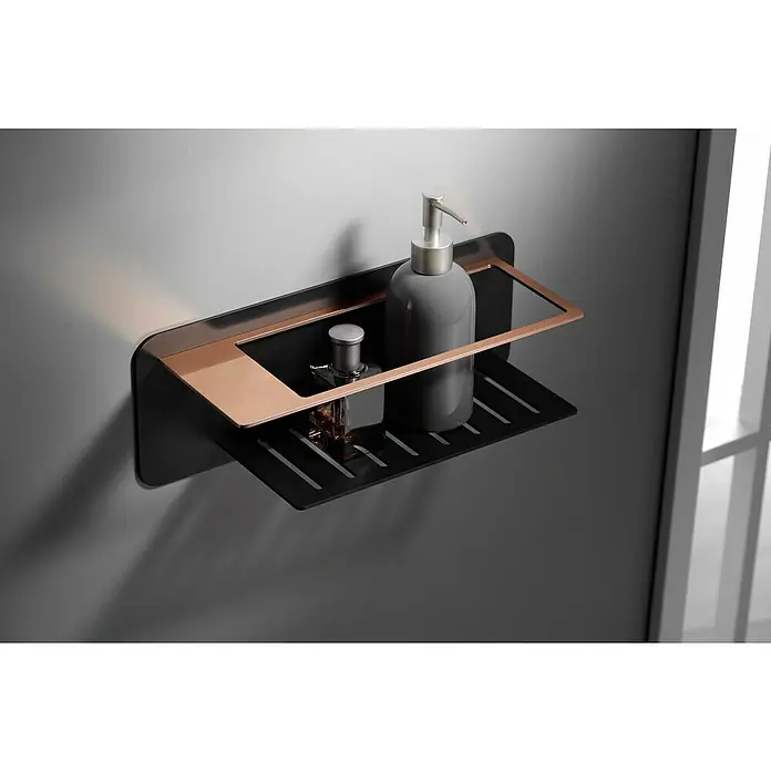 Imex Cesta de baño Bethari - 12,7 x 36 x 13,5 cm, Acero inoxidable, Negro/Oro rosa - Esta imagen muestra un moderno estante de baño con frasco de champú y perfume, montado en una pared gris. El estante es negro con detalles en cobre.