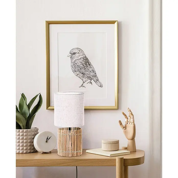 Idp Lampshades Lámpara de sobremesa Bocage - 40 W, L x An x Al: 15 x 15 x 31 cm, Natural, Blanco, E27 - La imagen muestra una mesa auxiliar decorativa con una lámpara, una planta, un reloj y una mano de madera, sobre un arte mural de un pájaro.