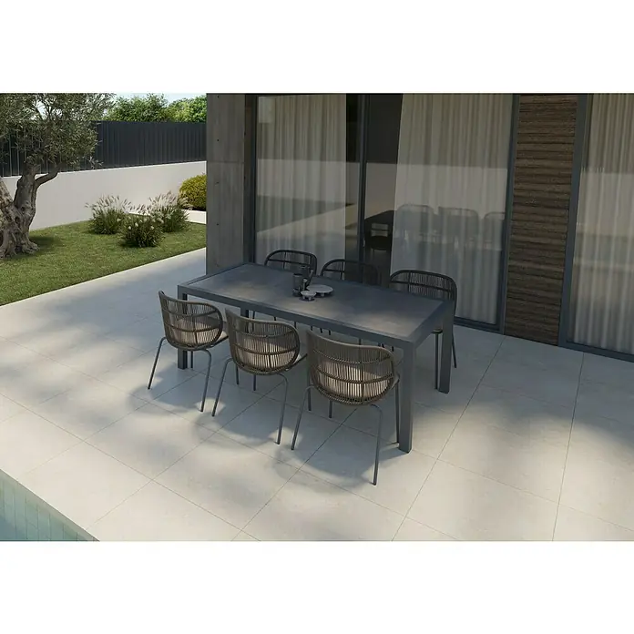 Mesa de jardín Mistral - L x An x Al: 192 x 102 x 74 cm, Aluminio/Cerámica, Antracita - Una mesa de comedor gris con seis sillas de ratán se encuentra en un patio, perfecta para comidas al aire libre. Diseño elegante y moderno.