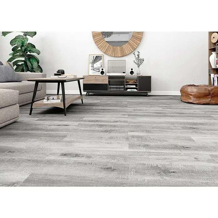 LOGOCLIC Laminado Roble Jarama - 1.200 x 196 x 8 mm, AC4 - Una sala de estar elegante con modernos pisos de madera gris, creando un ambiente sereno y acogedor. Ideal para un hogar contemporáneo.