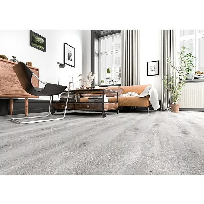 LOGOCLIC Laminado Roble Jarama - 1.200 x 196 x 8 mm, AC5 - Una habitación luminosa con suelo de madera gris, creando un ambiente moderno y acogedor. Muebles y decoración complementan el diseño elegante.