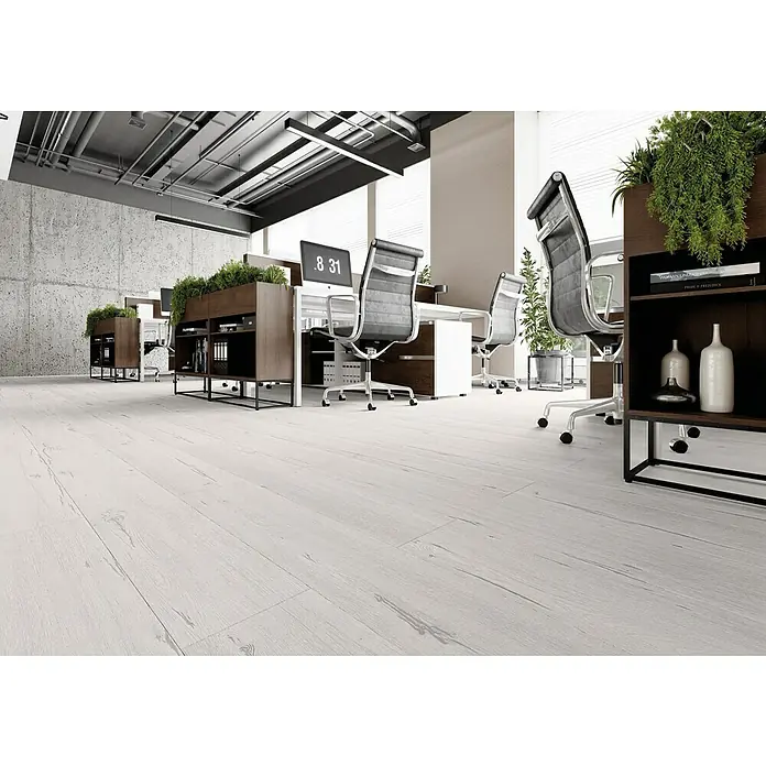 LOGOCLIC Laminado Roble Snow - 1.200 x 196 x 8 mm, AC5 - Interior de oficina con suelos de madera clara, sillas de oficina modernas, islas de oficina llenas de vegetación y paredes de hormigón, creando un espacio de trabajo elegante y productivo.