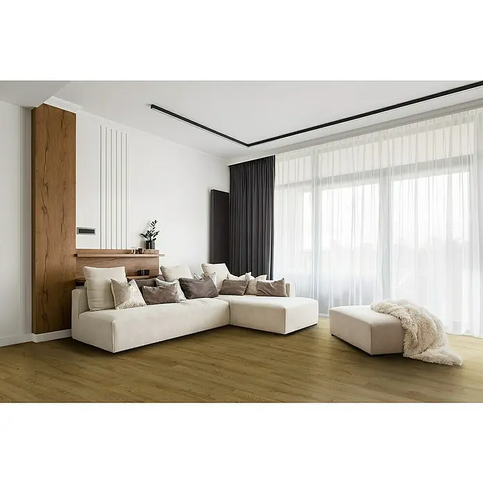 Allure Suelo vinílico SPC Amsterdam Natural - 1.220 x 226 x 5,2 mm, Marrón, Resistente al agua - Elegante salón con sofá seccional beige, cojines decorativos y otomanas sobre un cálido suelo de madera, acentuado con cortinas oscuras e iluminación moderna.