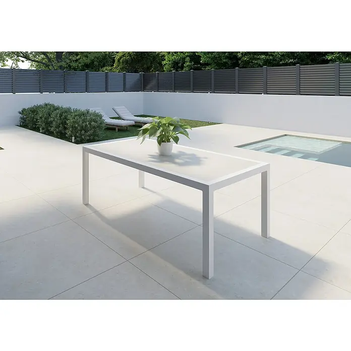 Mesa de jardín Mistral - L x An x Al: 192 x 102 x 74 cm, Aluminio/Cerámica, Blanco - Imagen de una moderna mesa de comedor exterior blanca con una planta en maceta, sobre un patio y una exuberante vegetación.