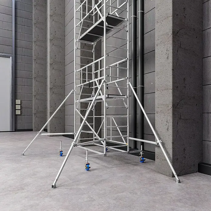 Krause ProTec XS Klappgerüst - Arbeitshöhe: 11,8 m, Belastbarkeit Plattform: 240 kg - Ein modulares, rollbares Baugerüst aus Aluminium vor einer Betonwand mit Rohren, ideal für flexible Arbeiten in verschiedenen Höhen.