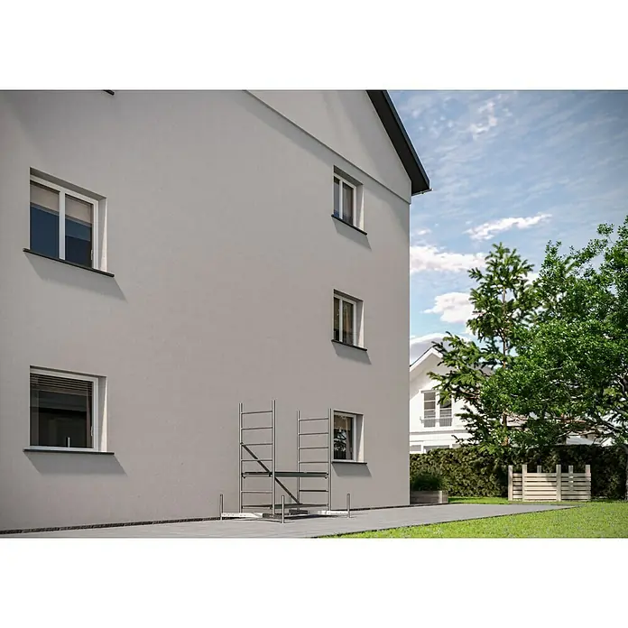 Krause ClimTec Rollgerüst - Arbeitshöhe: 3 m - Eine Fassade eines dreistöckigen Gebäudes mit Fenstern und einem Gerüst davor. Der Bau wirkt modern mit einer schlichten Farbgebung.