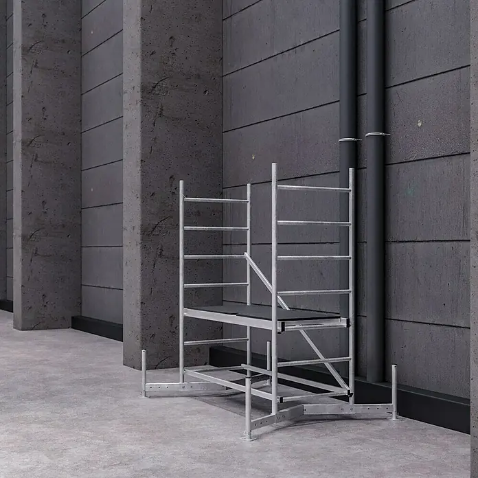 Krause ClimTec Rollgerüst - Arbeitshöhe: 3 m - Dieses Bild zeigt ein kleines, silbernes Gerüst in einem modernen Gebäude. Das Gerüst scheint für Wartungsarbeiten oder kleine Reparaturen geeignet zu sein.