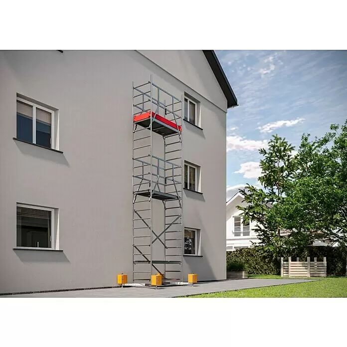 Krause ClimTec Leitergerüst - Arbeitshöhe: 7 m, Ohne Rollen - Ein hohes silbernes Metallgerüst mit roten Plattformen steht an der hellgrauen Fassade eines Hauses, gestützt von gelben Füßen.