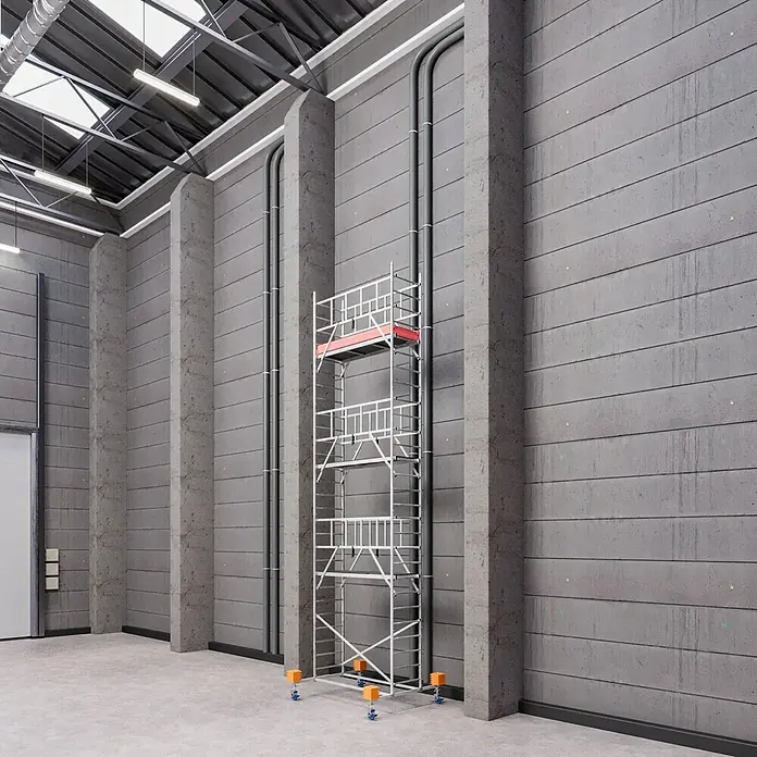 Krause ProTec Rollgerüst - Arbeitshöhe: 8,3 m, Belastbarkeit Plattform: 240 kg - Dieses Bild zeigt ein hohes, silbernes Baugerüst mit roten Akzenten, das in einer geräumigen Halle mit Betonwänden und industriellem Design steht.