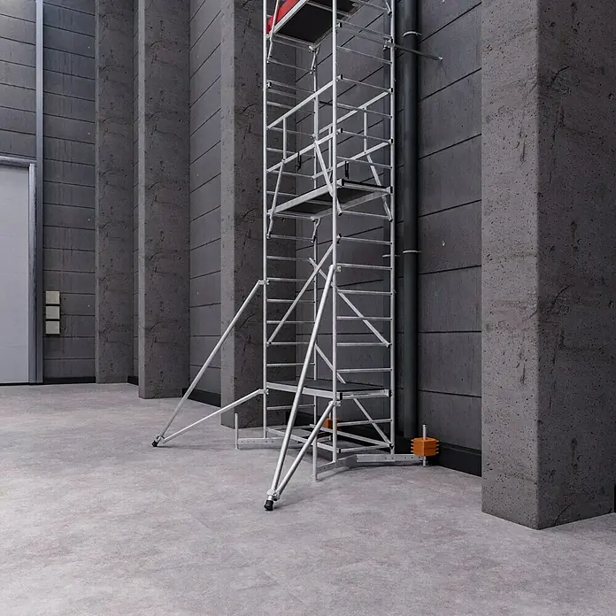 Krause ClimTec Aufstockelement 2. Aufstockung - Arbeitshöhe: 7 m - Aufnahme eines hohen, silbernen Gerüsts, das in einem industriellen Raum mit Betonwänden steht.