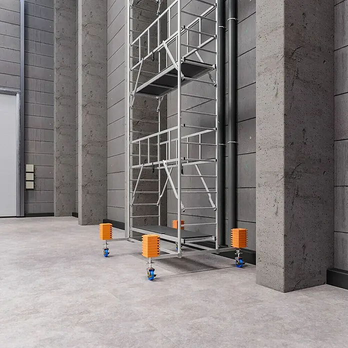 Krause ProTec RollgerüstArbeitshöhe: 11,3 m, Bühnengröße: 2 x 0,6 m, Belastbarkeit: 200 kg/m² - Ein hoher Gerüstturm mit orangefarbenen Stapelblöcken und blauen Rädern steht in einem Betongebäude. Das Gerüst ist aus Metall und bietet hohe Stabilität.