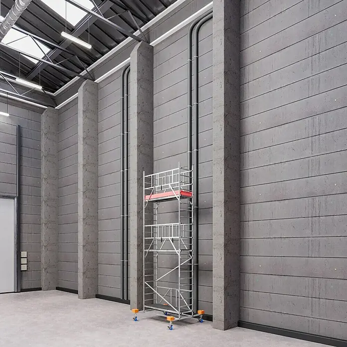 Krause ProTec XS KlappgerüstArbeitshöhe: 6,8 m, Bühnengröße: 2 x 0,6 m, Belastbarkeit: 200 kg/m² - Silbernes Baugerüst mit roter Plattform in einer Lagerhalle. Es steht an einer grauen Betonwand für Bau- oder Wartungsarbeiten.
