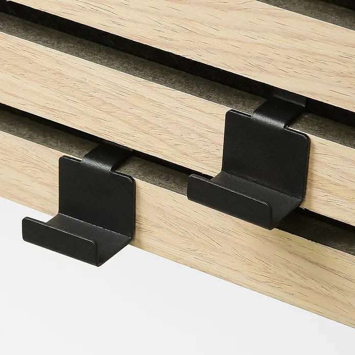 Millex Paneelkrallen Horizontal & Vertikal - L x B x H: 2,2 x 3 x 4,7 cm, Passend für: Akustikpaneele, Montageart: Einhängen - Nahaufnahme von zwei schwarzen Haken an einer hellen Holzstruktur. Die Haken sind robust und ideal zum Aufhängen von Gegenständen.