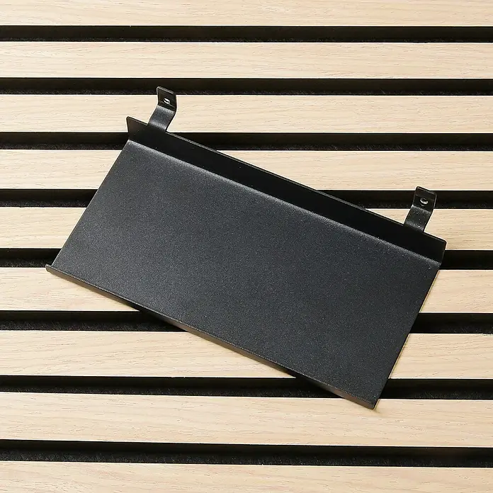 Millex Regal - L x B x H: 9,5 x 20 x 5 cm, Passend für: Akustikpaneele, Montageart: Einhängen - Eine Nahaufnahme eines schwarzen Regals mit Halterungen, das auf einem Hintergrund aus Holzlatten liegt. Perfekt für die stilvolle Aufbewahrung.