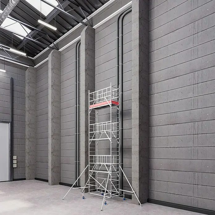 Krause ProTec XS Klappgerüst - Arbeitshöhe: 7,8 m, Belastbarkeit Plattform: 240 kg - Ein stabiles, silbernes Baugerüst steht vor einer grauen Wand und bietet sicheren Zugang für Bau- und Renovierungsarbeiten.