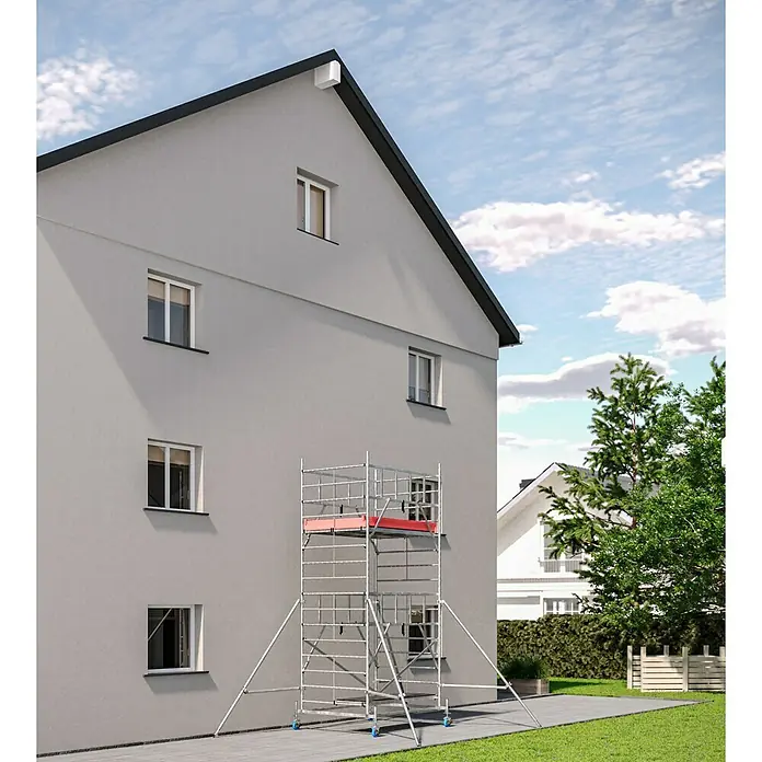 Krause ProTec XXL Rollgerüst BreitaufbauArbeitshöhe: 5,3 m, Bühnengröße: 2 x 1,2 m, Belastbarkeit: 200 kg/m² - Eine zweistöckige Rollgerüst-Konstruktion aus Metall mit roter Plattform steht vor einer hellgrauen Hauswand mit Fenstern.