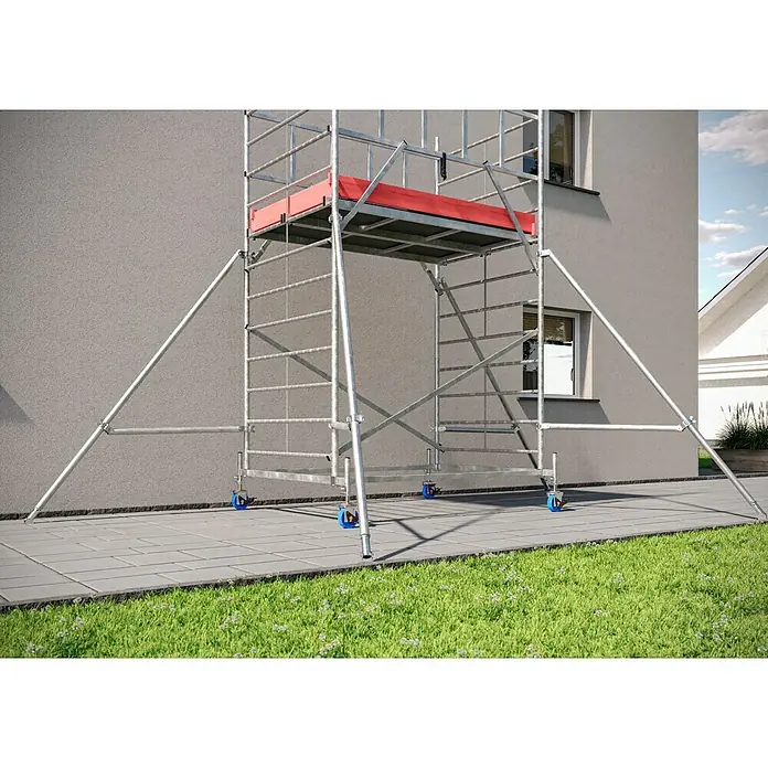 Krause ProTec XXL Rollgerüst Breitaufbau - Arbeitshöhe: 6,3 m, Belastbarkeit Plattform: 480 kg - Ein robustes Gerüst mit roter Plattform steht auf einem gepflasterten Untergrund vor einem Gebäude. Das Gerüst ist mit blauen Rollen ausgestattet.