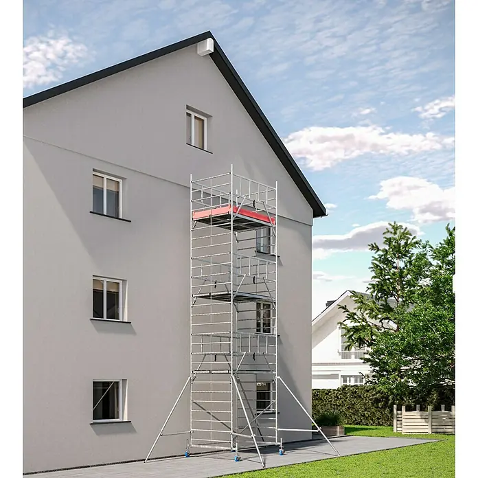 Krause ProTec XXL Rollgerüst Breitaufbau - Arbeitshöhe: 8,3 m, Belastbarkeit Plattform: 480 kg - Ein hohes, silbernes Baugerüst steht vor einem grauen Haus und ermöglicht Arbeiten in der Höhe mit sicherer Plattform.