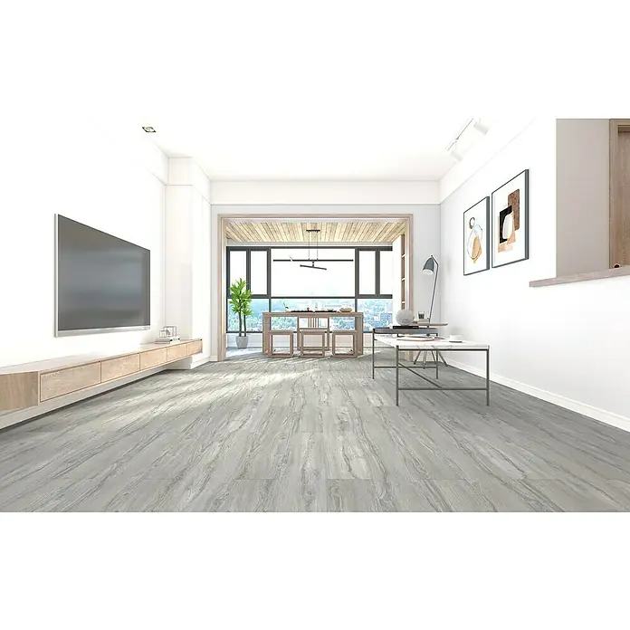 Suelo vinílico SPC Everest - 1.220 x 182 x 5,5 mm, Resistente al agua - Una sala de estar luminosa y moderna con suelo de madera gris, muebles minimalistas y mucha luz natural. El suelo de madera gris es la característica dominante.